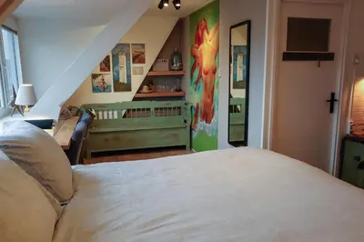 a bedroom with a bed and a crib in a room at Zee-en-Zo Noordwijk in Noordwijk