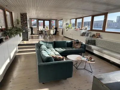 a living room with two couches and a table at Stunning boat with a view in Amsterdam