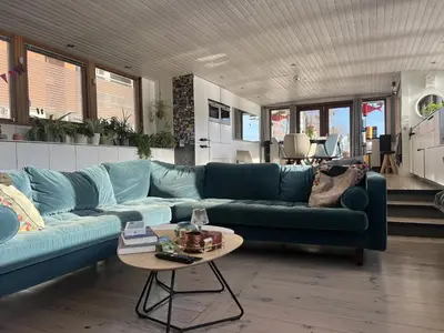 a living room with a blue couch and a table at Stunning boat with a view in Amsterdam