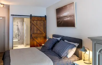 a bedroom with a bed and a sliding barn door at Boutique Hotel Herberg Binnen in Egmond-Binnen