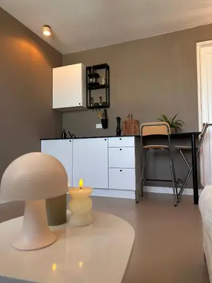 a living room with a table and a white kitchen at City & Nature-Amsterdam NextDoor Free parking 8 person 2 kitchens in Landsmeer