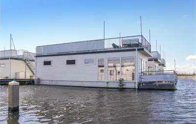 a building on a boat in the water at Nice Ship In Aalsmeer With Kitchen in Aalsmeer