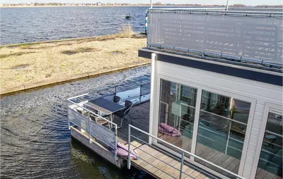 a boat on the water next to a house at Nice Ship In Aalsmeer With Kitchen in Aalsmeer