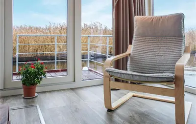 a rocking chair sitting in front of a window at Nice Ship In Aalsmeer With Kitchen in Aalsmeer