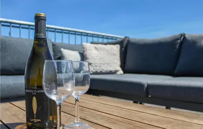a bottle of wine and two wine glasses on a table at Lovely Ship In Aalsmeer With Kitchen in Aalsmeer