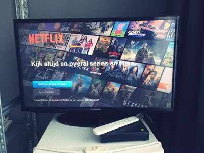 a tv sitting on top of a table with a remote control at Private studio, patio garden and free car parking in Amsterdam