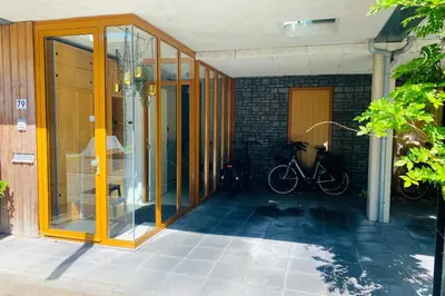 a house with glass doors and a bike parked outside at Private studio, patio garden and free car parking in Amsterdam