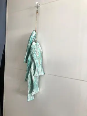 a metal angel ornament hanging on a wall at Studio Pipper in Zandvoort