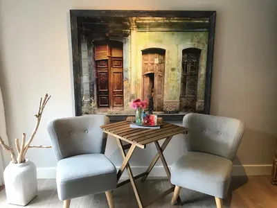 a table with two chairs and a painting on the wall at Studio Pipper in Zandvoort