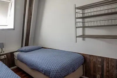 a small room with a bed and a shelf at 4T4 Apartment C in Egmond aan den Hoef