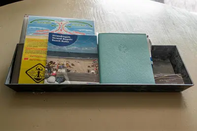 a box of books sitting on a table at 4T4 Apartment C in Egmond aan den Hoef