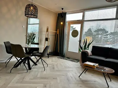 a living room with a table and a couch at Amsterdam Beach Apartment 34, Private Garden in Zandvoort