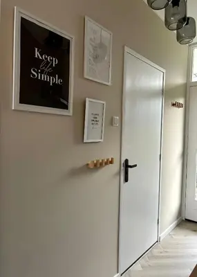 a hallway with a white door and a picture on the wall at Amsterdam Beach Apartment 34, Private Garden in Zandvoort