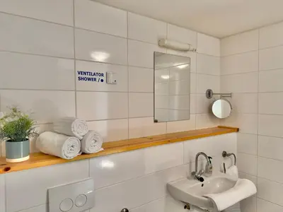 a bathroom with a sink and a mirror and towels at Appartementen Casa del Lago in Lisse