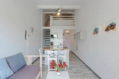 a living room with a couch and a kitchen at Appartementen Casa del Lago in Lisse