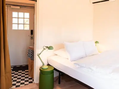a room with a bed and a lamp on the floor at SWEETS - Willemsbrug in Amsterdam