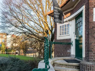 a street sign in front of a house at SWEETS - Willemsbrug in Amsterdam