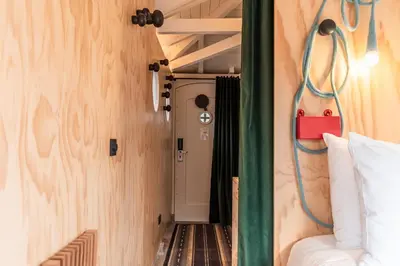 a small room with a bed and a door at SWEETS - Omvalbrug in Amsterdam