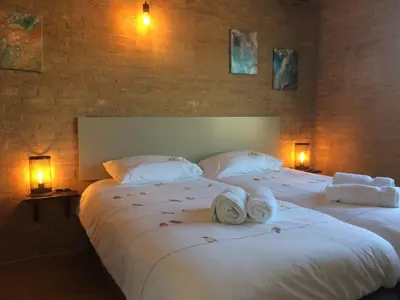 two beds in a hotel room with towels on them at Bungalow 221 in Noordwijkerhout