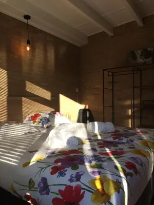 a bedroom with a large bed with a floral blanket at Bungalow 221 in Noordwijkerhout