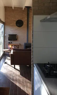 a kitchen with a couch and a table in a room at Bungalow 221 in Noordwijkerhout