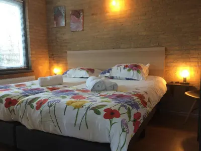 a bedroom with a large bed with flowers on it at Bungalow 221 in Noordwijkerhout