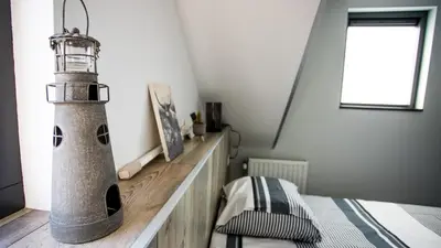 a bedroom with a lighthouse on a wooden table at B&B Joeys place in Egmond aan Zee