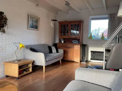 a living room with a couch and a chair at Holiday Home in Noordwijkerhout near Beach in Noordwijkerhout