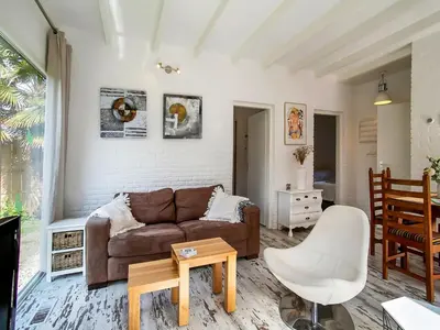 a living room with a couch and a table at Bungalow in Noordwijk near Beaches in Noordwijkerhout