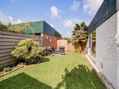 a backyard with a table and chairs in a yard at Bungalow in Noordwijk near Beaches in Noordwijkerhout