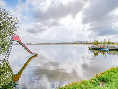 a view of a large lake with a red dock at Bungalow in Noordwijk near Beaches in Noordwijkerhout