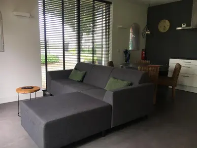 a living room with a couch and a table at Mooi appartement in een prachtige fiets-wandelomgeving in Abcoude