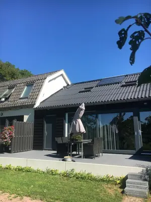 a house with a table and chairs in front of it at Ruim appartement in prachtige fiets-wandelomgeving in Abcoude