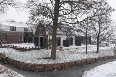 a house with a yard covered in snow at Ruim appartement in prachtige fiets-wandelomgeving in Abcoude