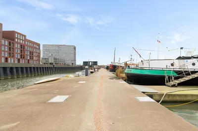 a dock with boats parked next to the water at B&B Houseboat Amsterdam in Amsterdam