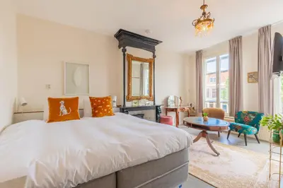 a bedroom with a large bed and a table at LOT Hotel in Leiden
