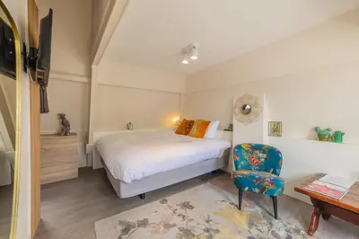 a bedroom with a bed and a chair and a desk at LOT Hotel in Leiden