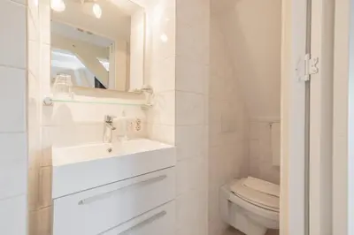 a white bathroom with a sink and a toilet at LOT Hotel in Leiden