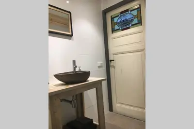 a bathroom with a sink next to a door at Landelijk appartement in een mooi recreatiegebied in Abcoude
