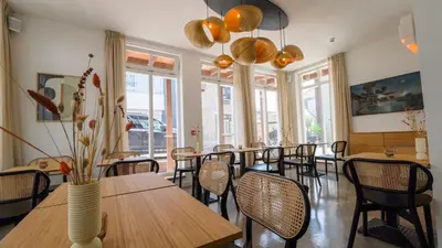 a dining room with tables and chairs and windows at Hotel Paradis Zandvoort in Zandvoort