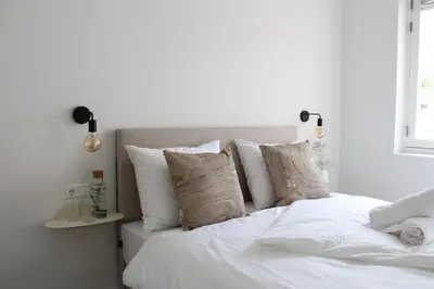 a white bed with white sheets and pillows at Hotel Paradis Zandvoort in Zandvoort
