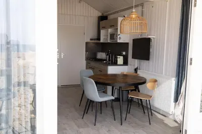 a kitchen with a table and chairs and a television at Willy Zuid in Katwijk aan Zee