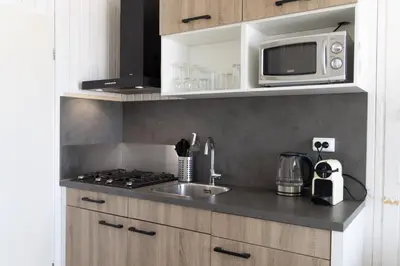 a kitchen with a sink and a microwave at Willy Zuid in Katwijk aan Zee