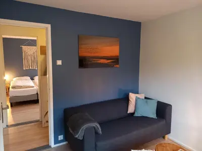a living room with a couch and a bedroom at Zeevonk Studio's & Appartementen in Katwijk aan Zee