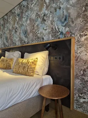 a bedroom with a bed with a table next to it at Zeevonk Studio's & Appartementen in Katwijk aan Zee