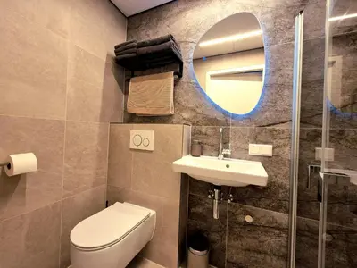 a bathroom with a toilet and a sink and a mirror at Zeevonk Studio's & Appartementen in Katwijk aan Zee