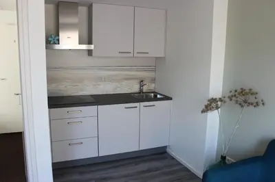 a kitchen with white cabinets and a sink at Zeevonk Studio's & Appartementen in Katwijk aan Zee