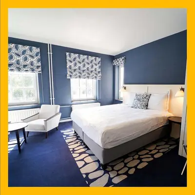 a bedroom with a king sized bed and a chair at Fletcher Hotel-Restaurant De Oude Gevangenis-Alkmaar in Alkmaar