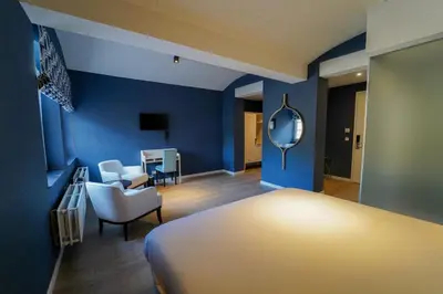 a room with a bed and a chair and a mirror at Fletcher Hotel-Restaurant De Oude Gevangenis-Alkmaar in Alkmaar