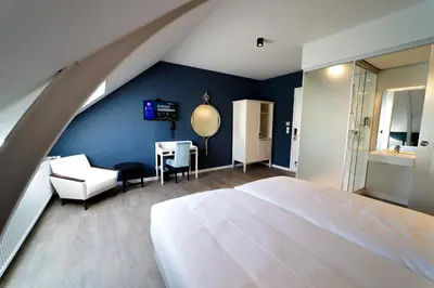 a bedroom with a white bed and a blue wall at Fletcher Hotel-Restaurant De Oude Gevangenis-Alkmaar in Alkmaar